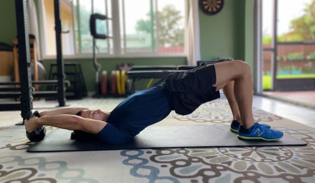 The supine bridge with overhead extension is a core exercise that challenges anti-flexion when you pull the weight.